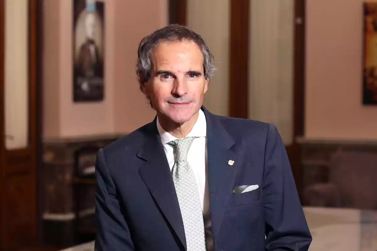 Gray-haired man with short hair wearing a blue suit and a light-colored tie in an elegant office Gray-haired man with short hair wearing a blue suit and a light-colored tie in an elegant office