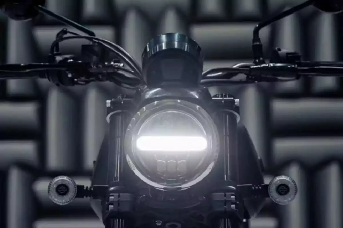 Motorcycle seen from the front with the headlight on in a soundproofed background environment Motorcycle seen from the front with the headlight on in a soundproofed background environment