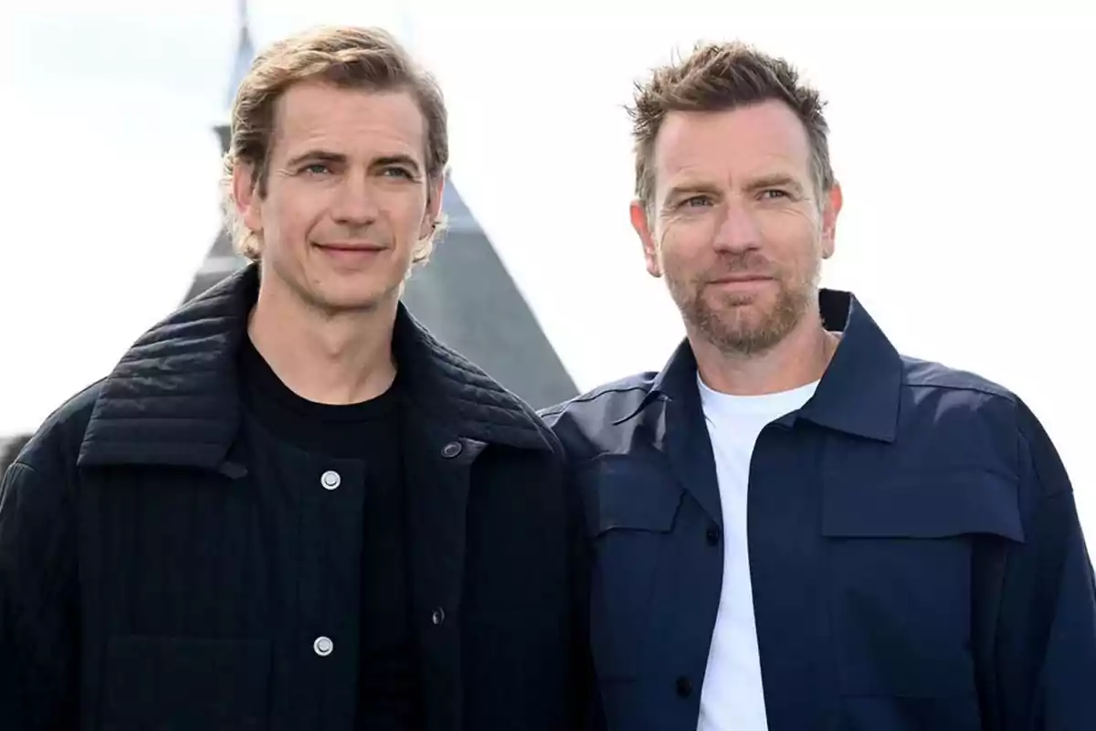 Two men pose together outdoors, both wearing dark jackets and looking forward with relaxed expressions. Two men pose together outdoors, both wearing dark jackets and looking forward with relaxed expressions.
