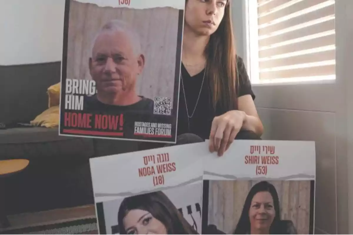 Seated woman holds signs with photos of missing people and messages asking for their return. Seated woman holds signs with photos of missing people and messages asking for their return.