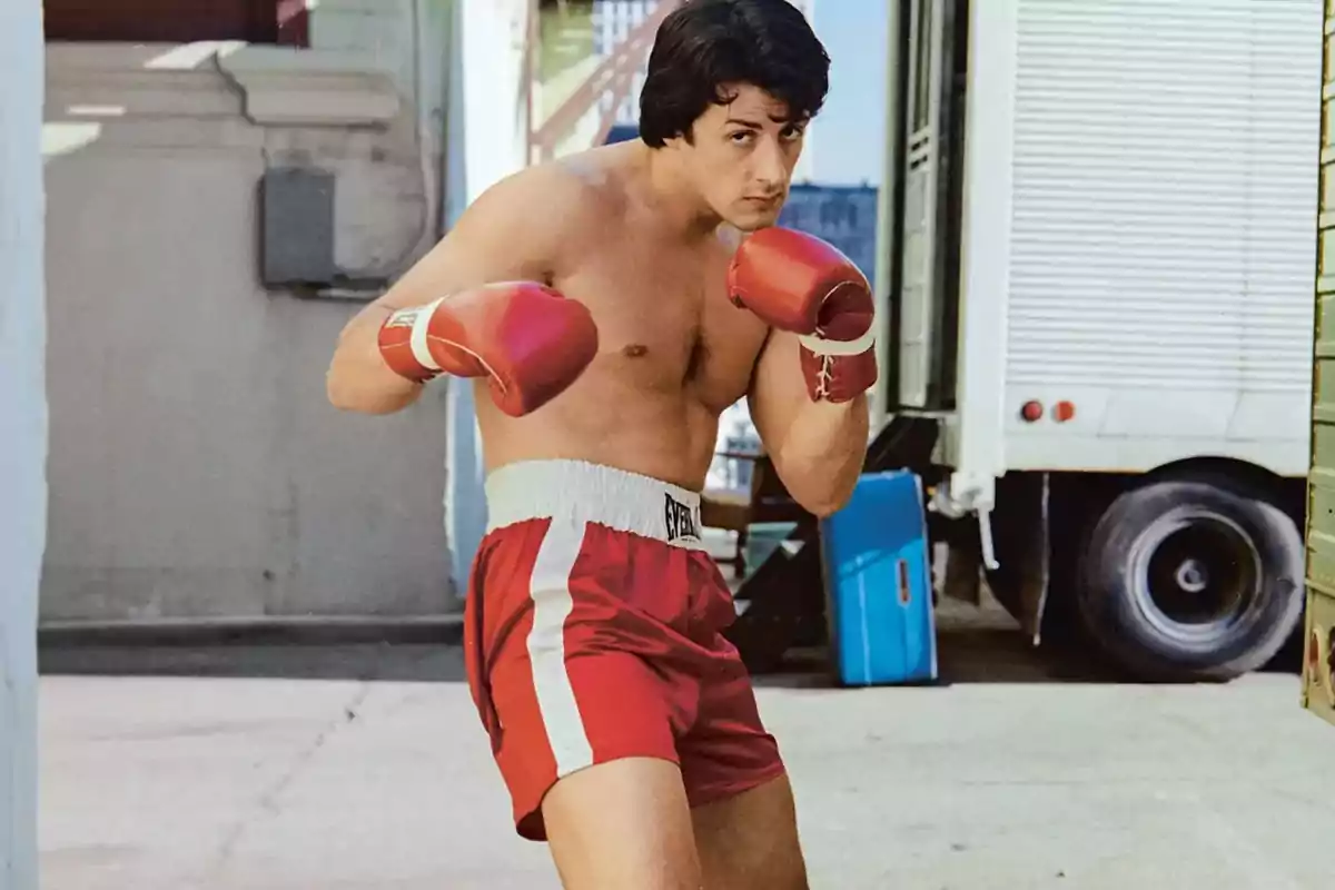 Young man with red boxing gloves and red shorts in a guard stance on an urban street Young man with red boxing gloves and red shorts in a guard stance on an urban street