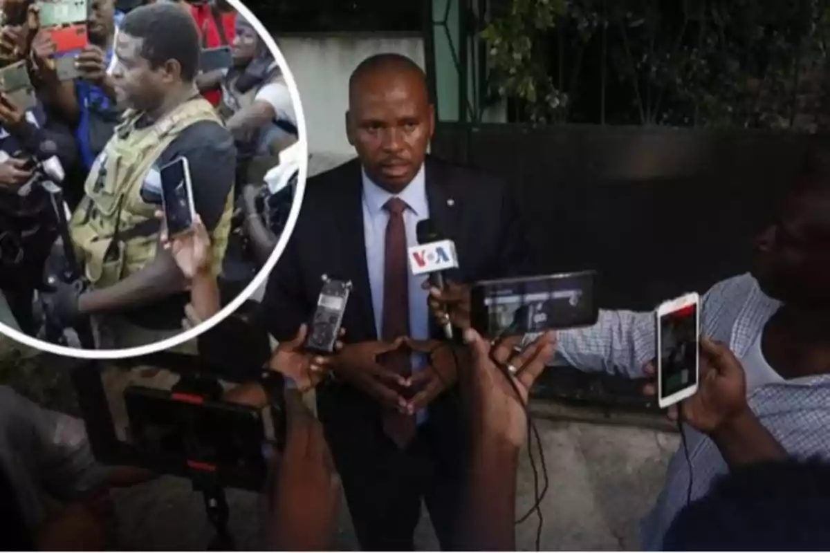 Un hombre con traje es entrevistado por varios periodistas que sostienen micrófonos y teléfonos mientras en un recuadro aparece un grupo de personas rodeando a un hombre con chaleco táctico