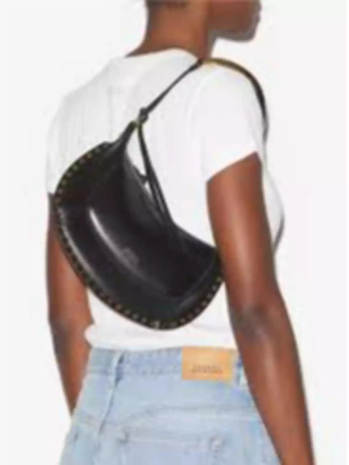 Mujer de espaldas con camiseta blanca, jeans claros y bolso negro al hombro Mujer de espaldas con camiseta blanca, jeans claros y bolso negro al hombro