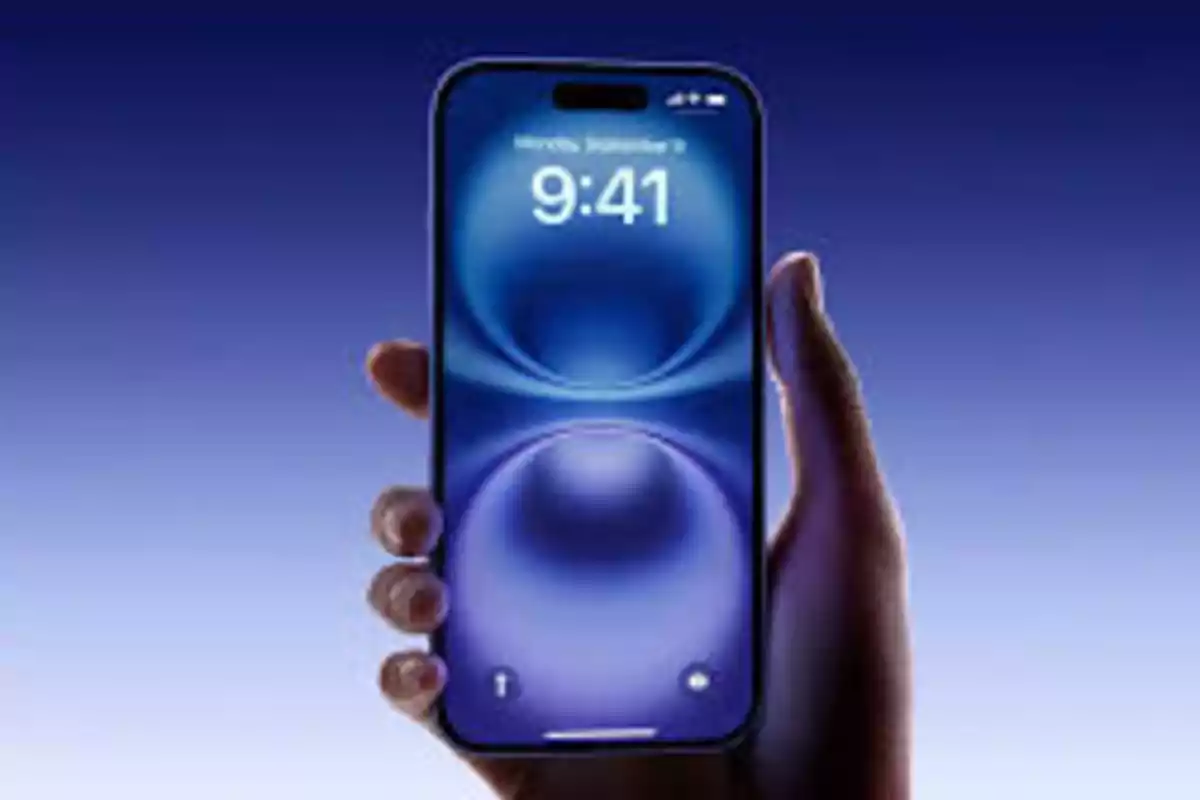 Person holding a modern smartphone with the screen on and a blue background Person holding a modern smartphone with the screen on and a blue background