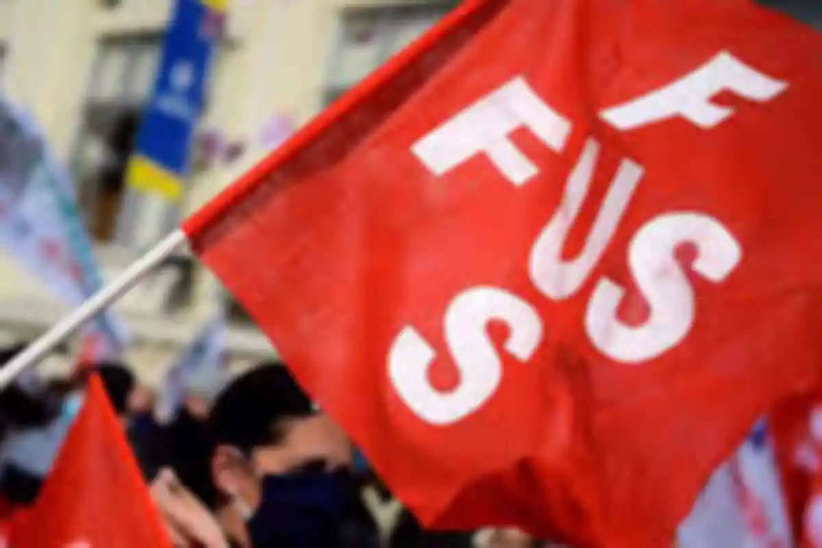 Bandera roja con las letras FUS en blanco sostenida durante una manifestación Bandera roja con las letras FUS en blanco sostenida durante una manifestación