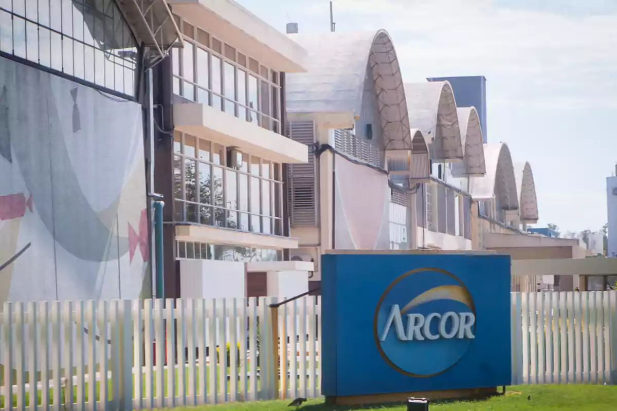 Arcor factory with a blue sign and an industrial building in the background Arcor factory with a blue sign and an industrial building in the background