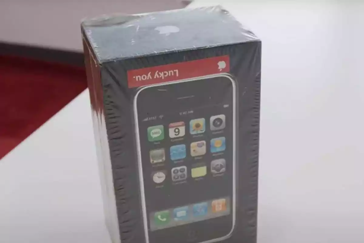 Caja sellada de un iPhone original de primera generación sobre una mesa blanca Caja sellada de un iPhone original de primera generación sobre una mesa blanca