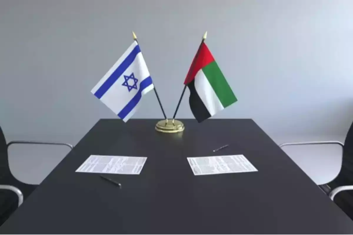 Two small flags of Israel and the United Arab Emirates on a black table with two documents and two pens, ready to be signed Two small flags of Israel and the United Arab Emirates on a black table with two documents and two pens, ready to be signed