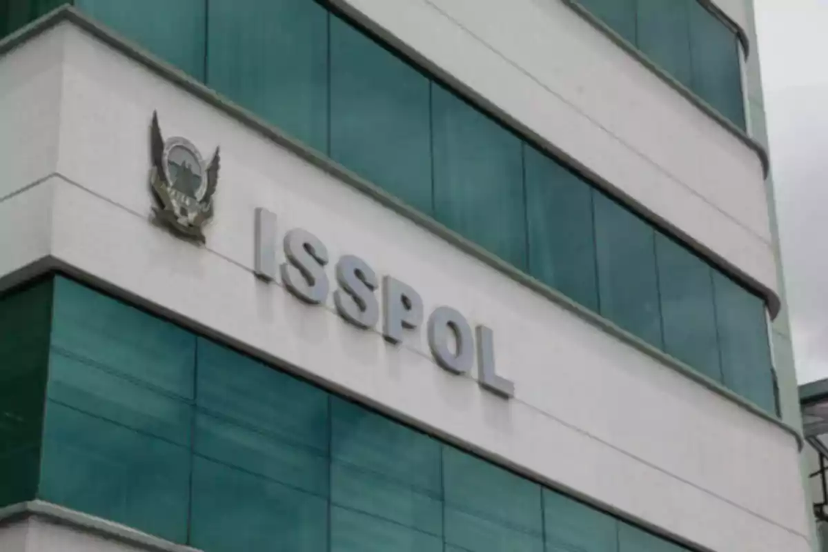 Fachada de un edificio con ventanas de vidrio y el letrero ISSPOL en letras grandes. Fachada de un edificio con ventanas de vidrio y el letrero ISSPOL en letras grandes.