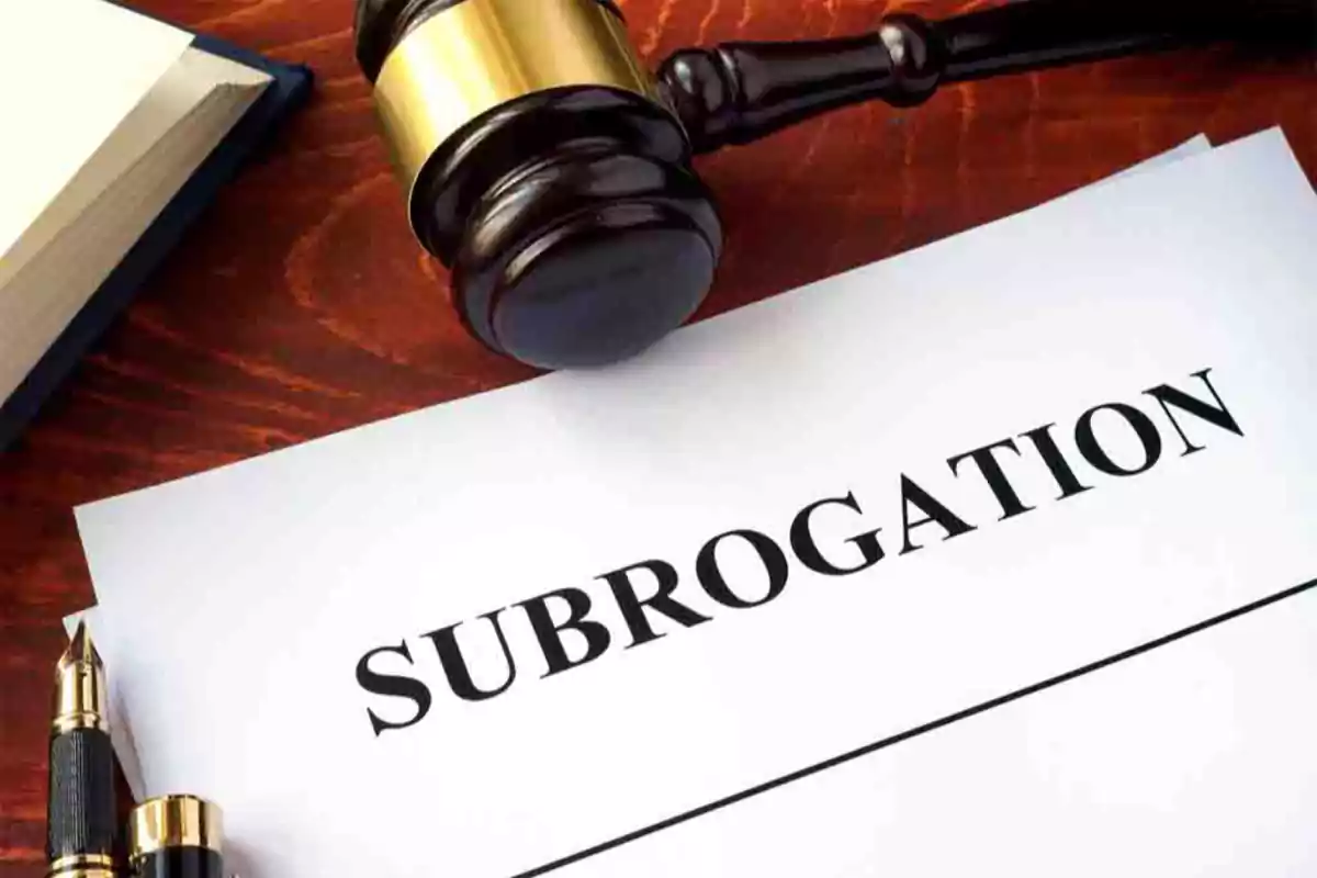 Document with the word subrogation on a table next to a judge's gavel, a book, and a fountain pen Document with the word subrogation on a table next to a judge's gavel, a book, and a fountain pen