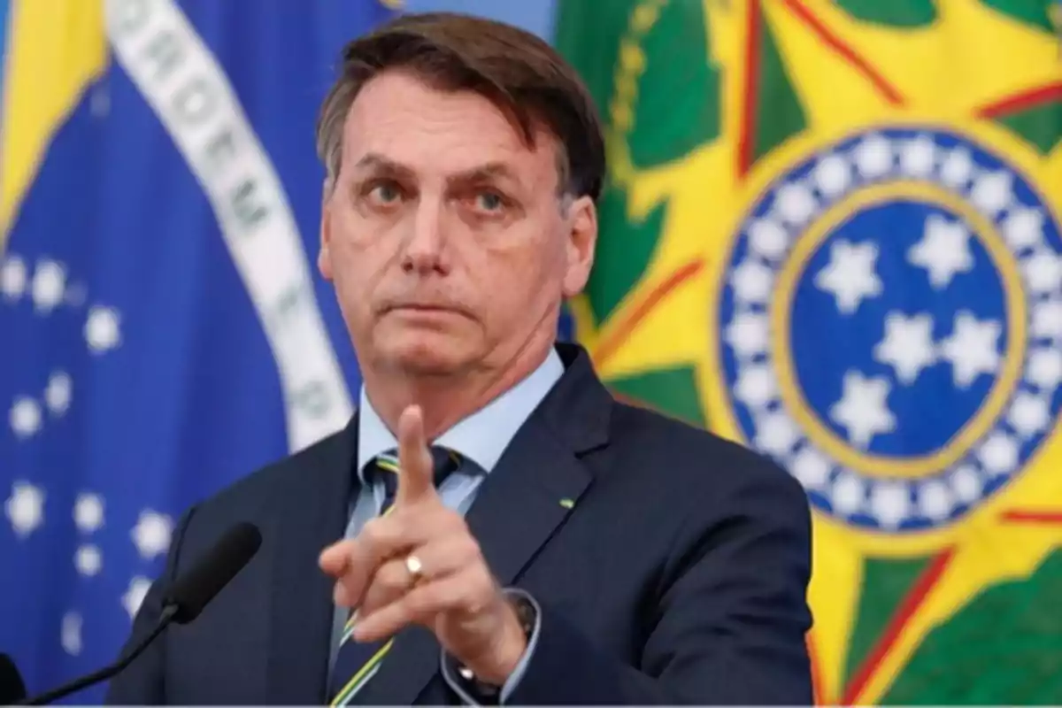 Man in a suit pointing with his finger in front of Brazilian flags Man in a suit pointing with his finger in front of Brazilian flags