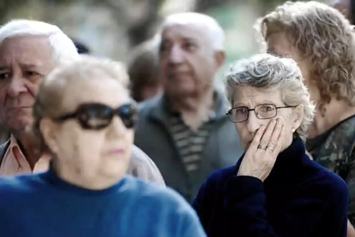 Group of elderly people with serious and thoughtful expressions in an outdoor setting Group of elderly people with serious and thoughtful expressions in an outdoor setting