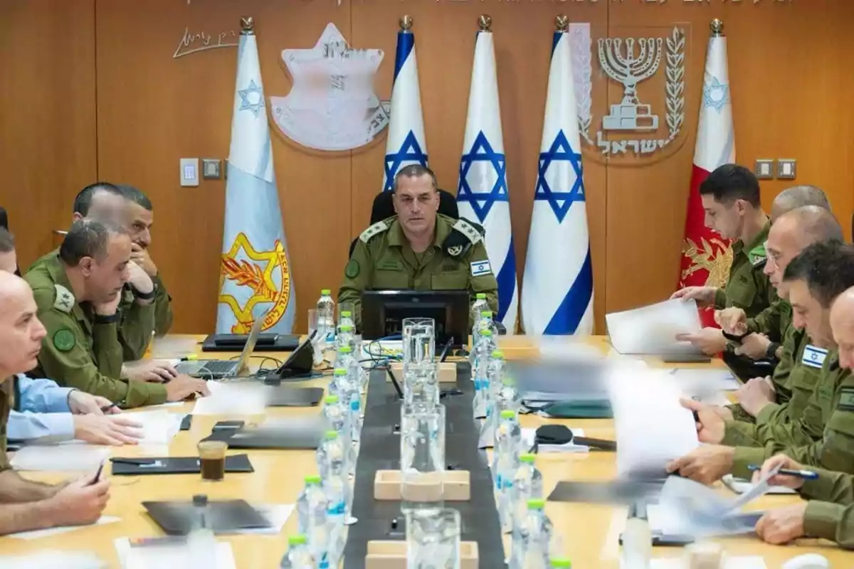 Reunión de altos mandos militares israelíes en una sala de conferencias con banderas y símbolos oficiales al fondo