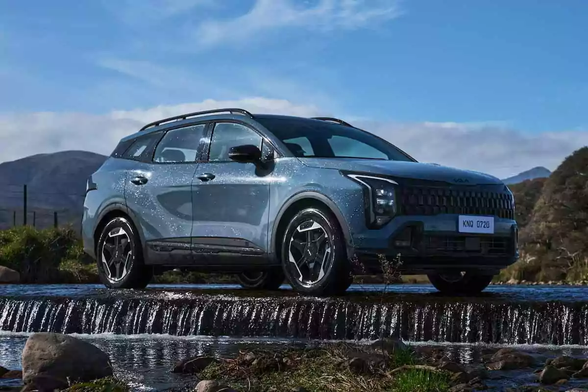 Gray SUV crossing a shallow stream with mountains and blue sky in the background Gray SUV crossing a shallow stream with mountains and blue sky in the background