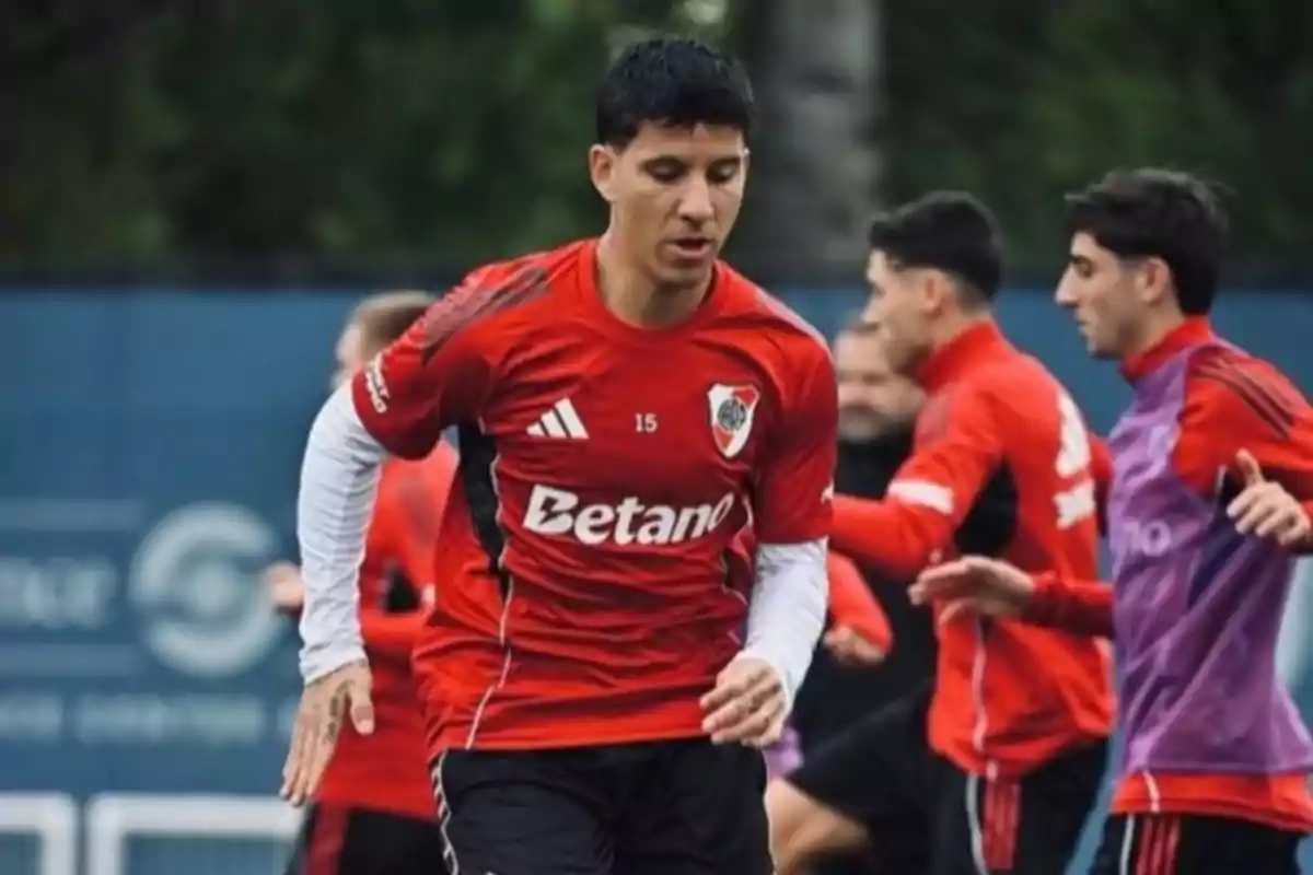 Futbolista con camiseta roja de River Plate entrenando junto a sus compañeros en una cancha al aire libre Futbolista con camiseta roja de River Plate entrenando junto a sus compañeros en una cancha al aire libre