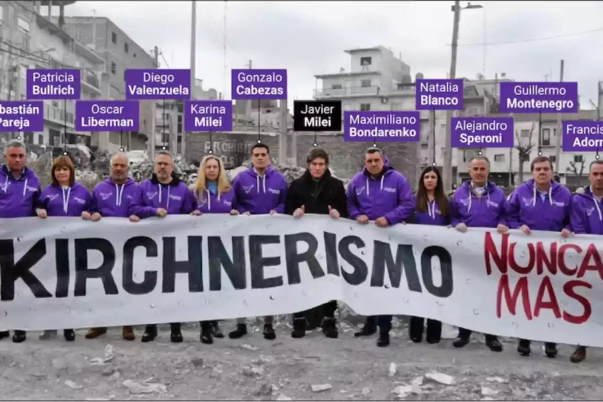 Grupo de personas con camperas violetas sosteniendo una pancarta que dice Kirchnerismo nunca más en un entorno urbano, con nombres identificativos sobre sus cabezas. Grupo de personas con camperas violetas sosteniendo una pancarta que dice Kirchnerismo nunca más en un entorno urbano, con nombres identificativos sobre sus cabezas.