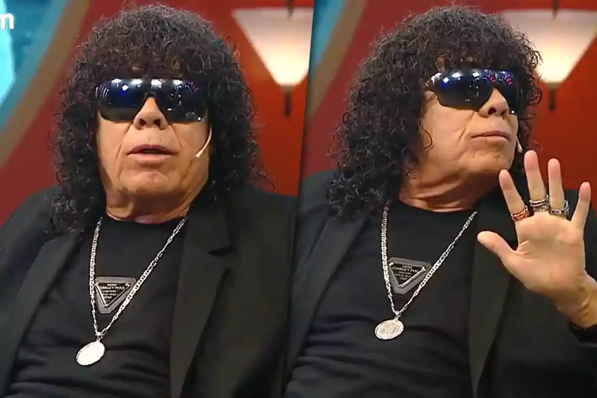 Curly-haired, dark-haired man wearing sunglasses, dressed in black and wearing necklaces, appears in two different poses during an interview on a television set.