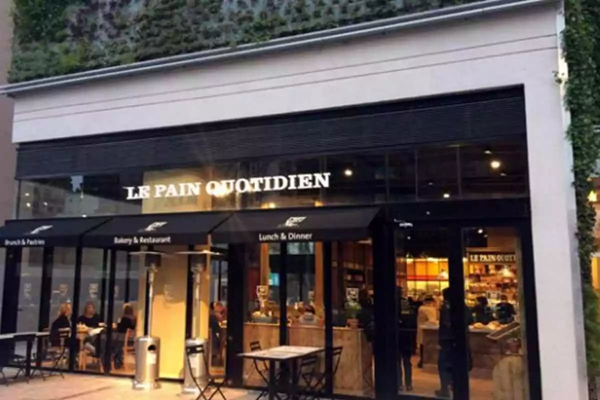 Facade of the Le Pain Quotidien café with tables and people sitting on the terrace Facade of the Le Pain Quotidien café with tables and people sitting on the terrace