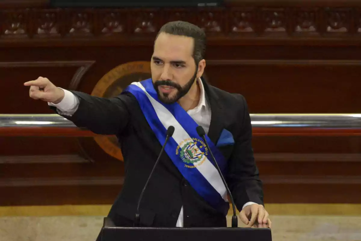 Hombre con banda presidencial azul y blanca hablando en un podio y señalando con el dedo en un recinto oficial Hombre con banda presidencial azul y blanca hablando en un podio y señalando con el dedo en un recinto oficial