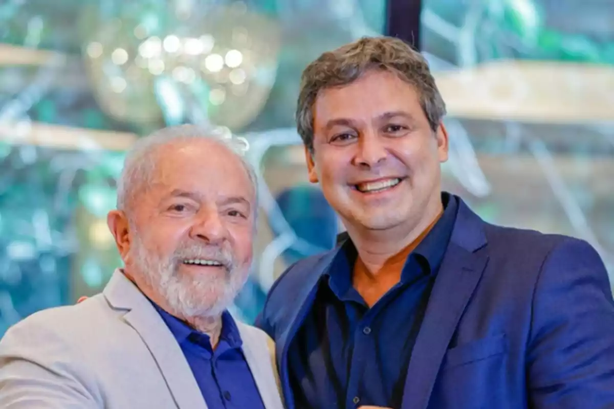 Dos hombres sonríen y posan juntos usando sacos en un ambiente iluminado y elegante Dos hombres sonríen y posan juntos usando sacos en un ambiente iluminado y elegante