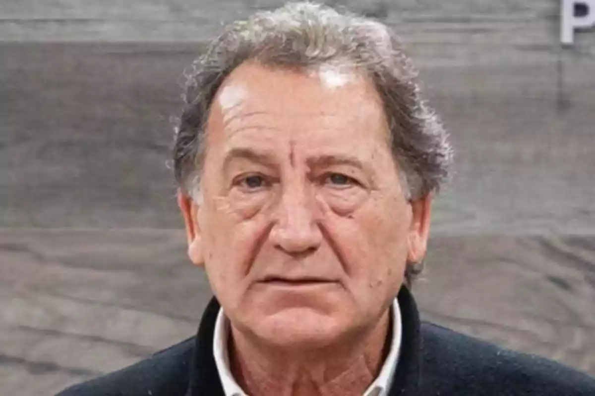 Gray-haired man with a serious expression against a wooden background Gray-haired man with a serious expression against a wooden background