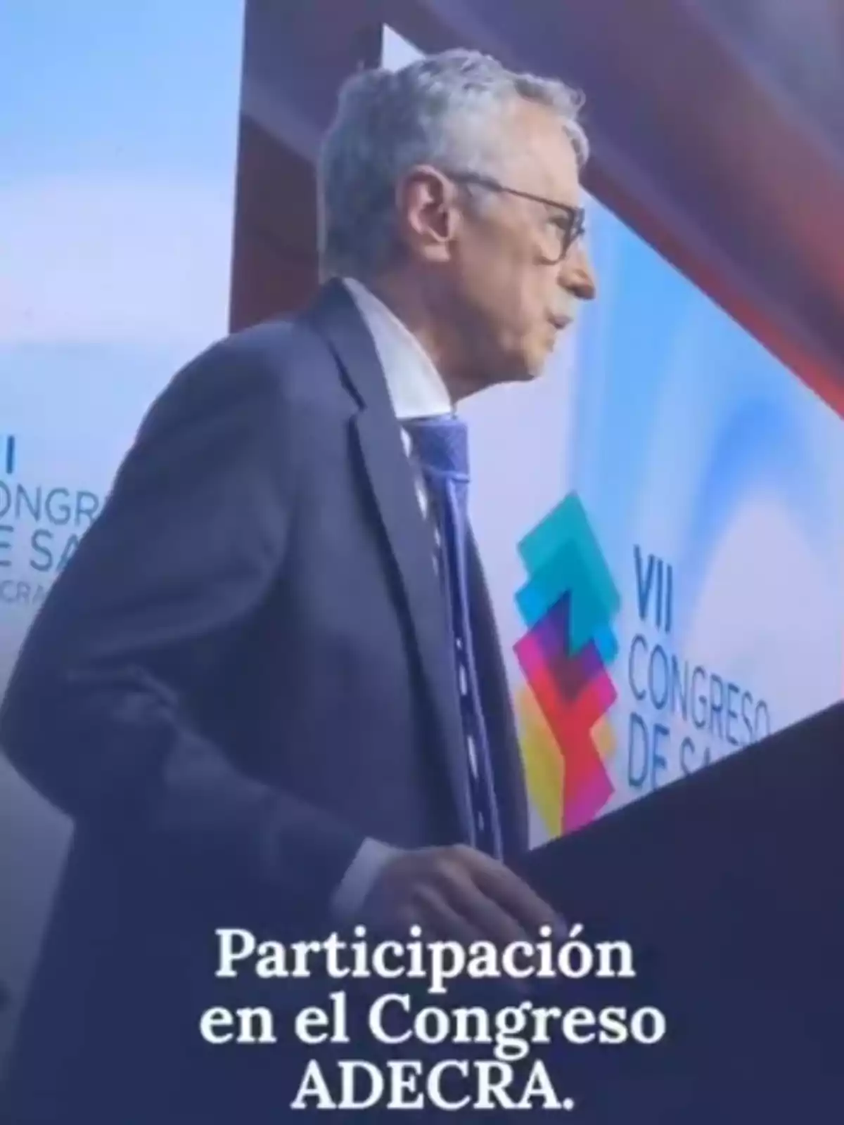 Hombre de cabello canoso y gafas hablando en un podio durante el VII Congreso de Salud ADECRA Hombre de cabello canoso y gafas hablando en un podio durante el VII Congreso de Salud ADECRA