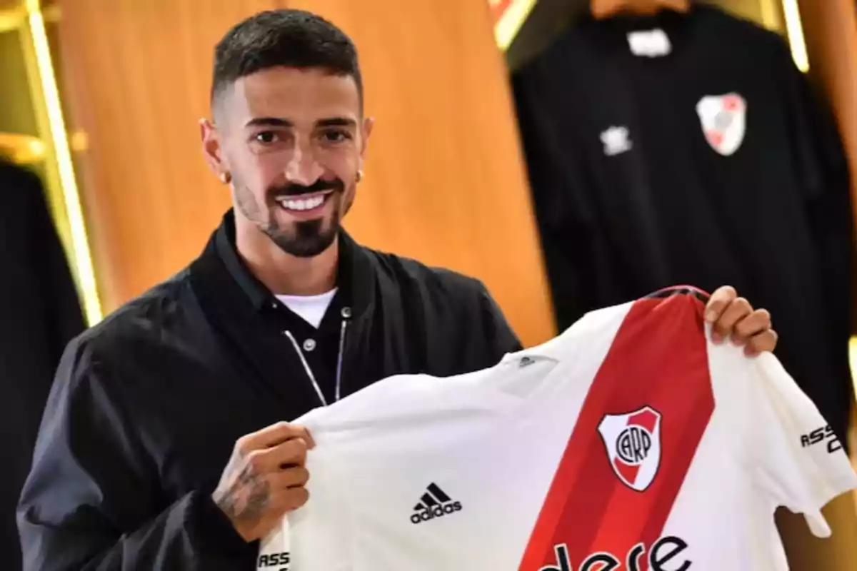 Smiling man holding a River Plate soccer jersey Smiling man holding a River Plate soccer jersey