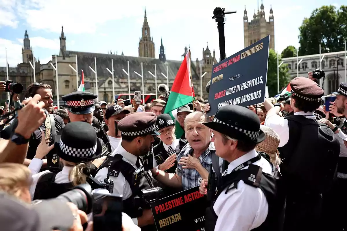 Protesters and police clash during a demonstration in London with Palestinian flags and signs, while photographers and journalists document the scene in front of historic buildings. Protesters and police clash during a demonstration in London with Palestinian flags and signs, while photographers and journalists document the scene in front of historic buildings.