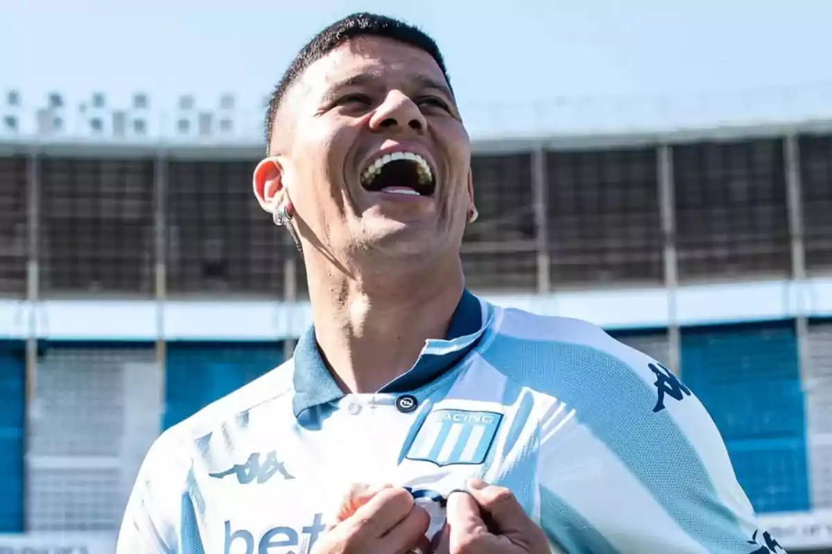 Futbolista sonriente con la camiseta de Racing Club en un estadio