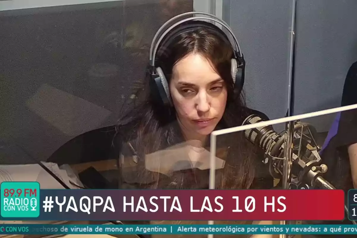 Mujer con auriculares sentada frente a un micrófono en una cabina de radio con el texto YAQPA HASTA LAS 10 HS en la parte inferior Mujer con auriculares sentada frente a un micrófono en una cabina de radio con el texto YAQPA HASTA LAS 10 HS en la parte inferior