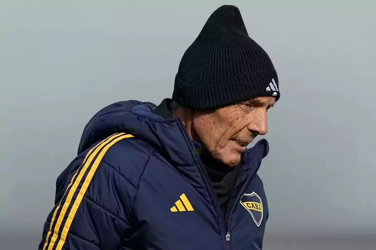 Older man with a black beanie and a blue Boca Juniors jacket looking down Older man with a black beanie and a blue Boca Juniors jacket looking down