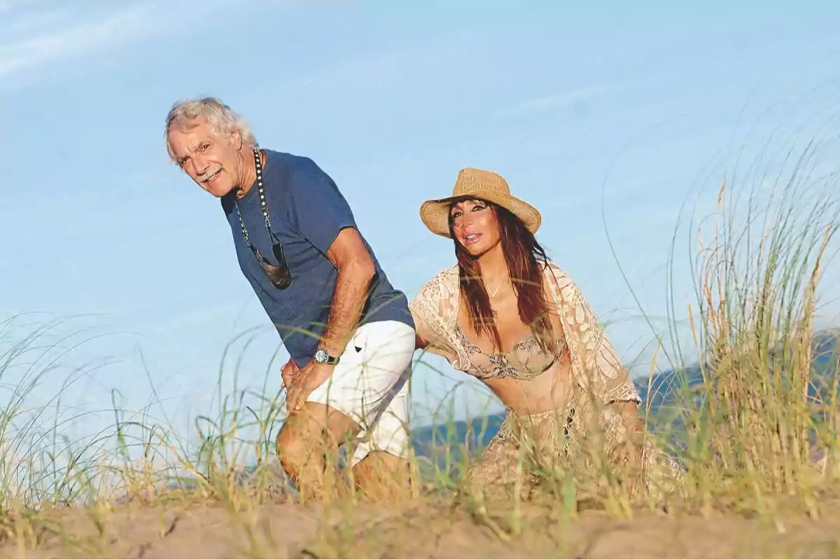 Pareja disfrutando de un día soleado en la playa entre dunas y vegetación Pareja disfrutando de un día soleado en la playa entre dunas y vegetación