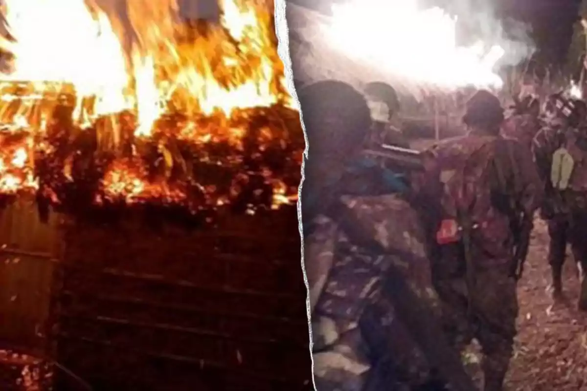 Palm-thatched house engulfed in flames as several people in camouflage clothing watch the fire at night