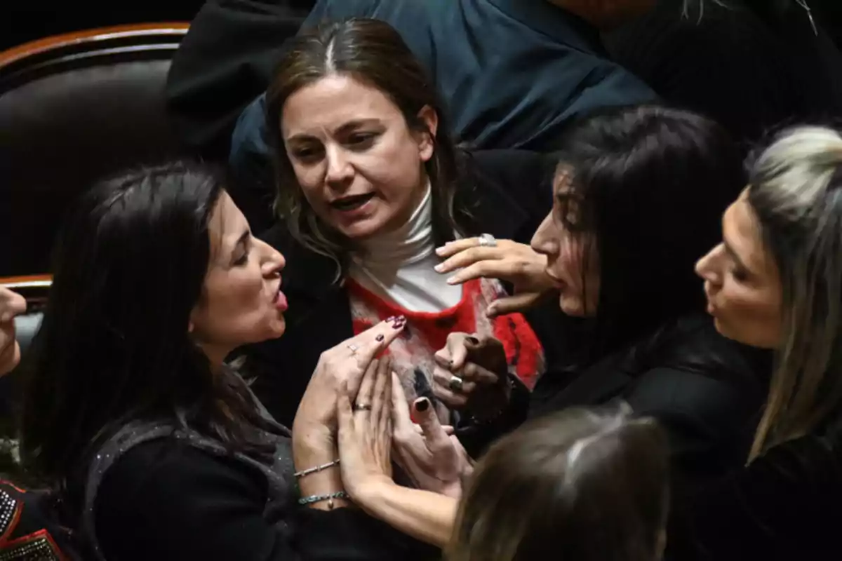 Several women argue heatedly and gesture with their hands in a formal setting. Several women argue heatedly and gesture with their hands in a formal setting.