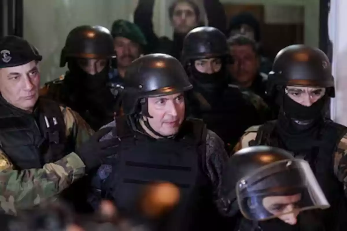 Grupo de policías fuertemente armados y con cascos escoltan a un hombre en medio de un operativo Grupo de policías fuertemente armados y con cascos escoltan a un hombre en medio de un operativo