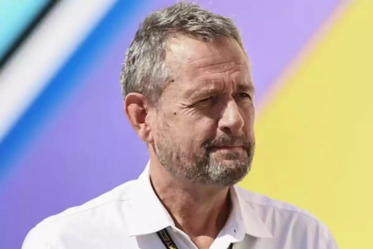 Short-haired, bearded man in a white jersey in front of a colorful blurred background Short-haired, bearded man in a white jersey in front of a colorful blurred background