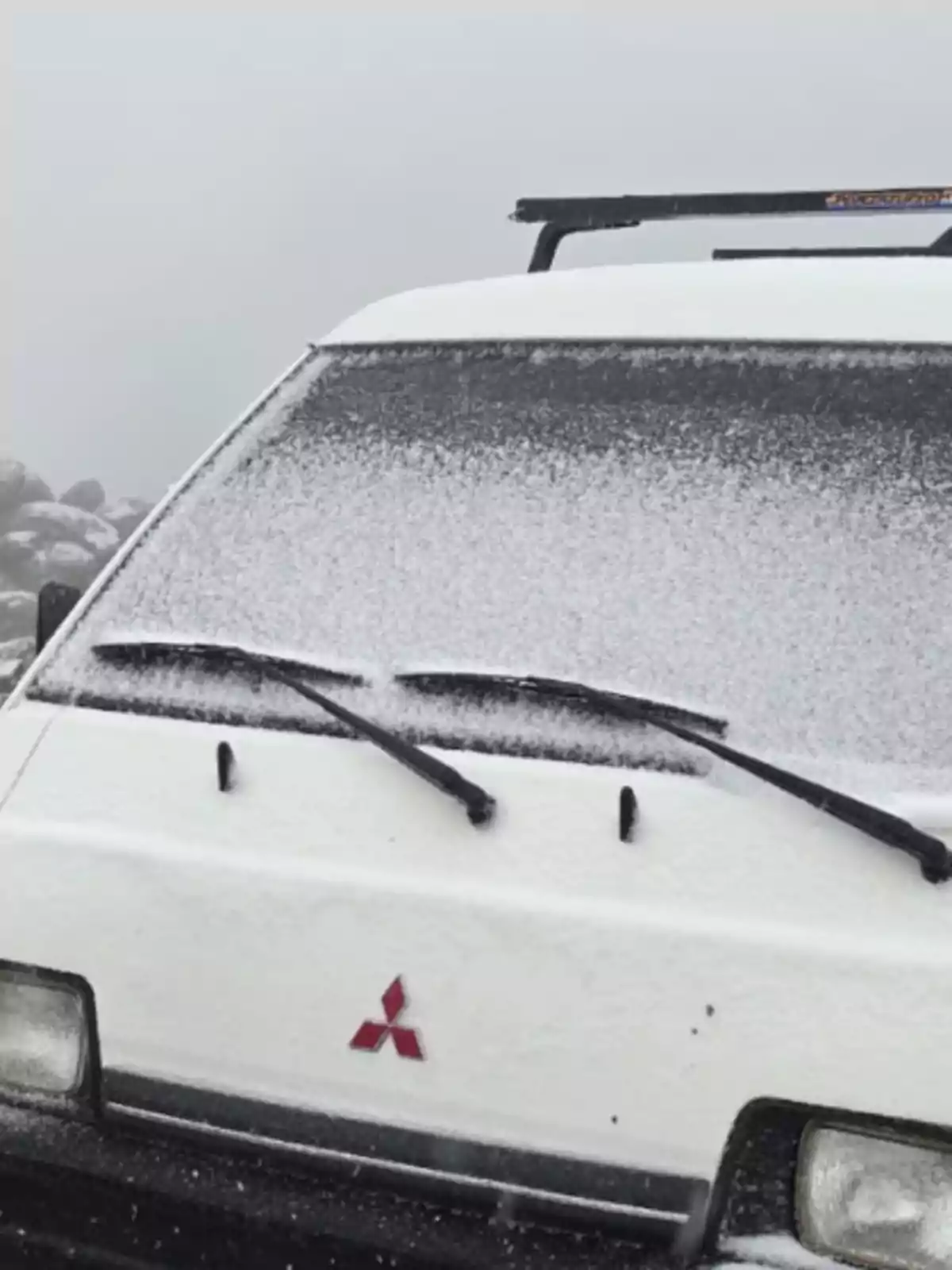 Frente de una camioneta Mitsubishi cubierta de nieve Frente de una camioneta Mitsubishi cubierta de nieve