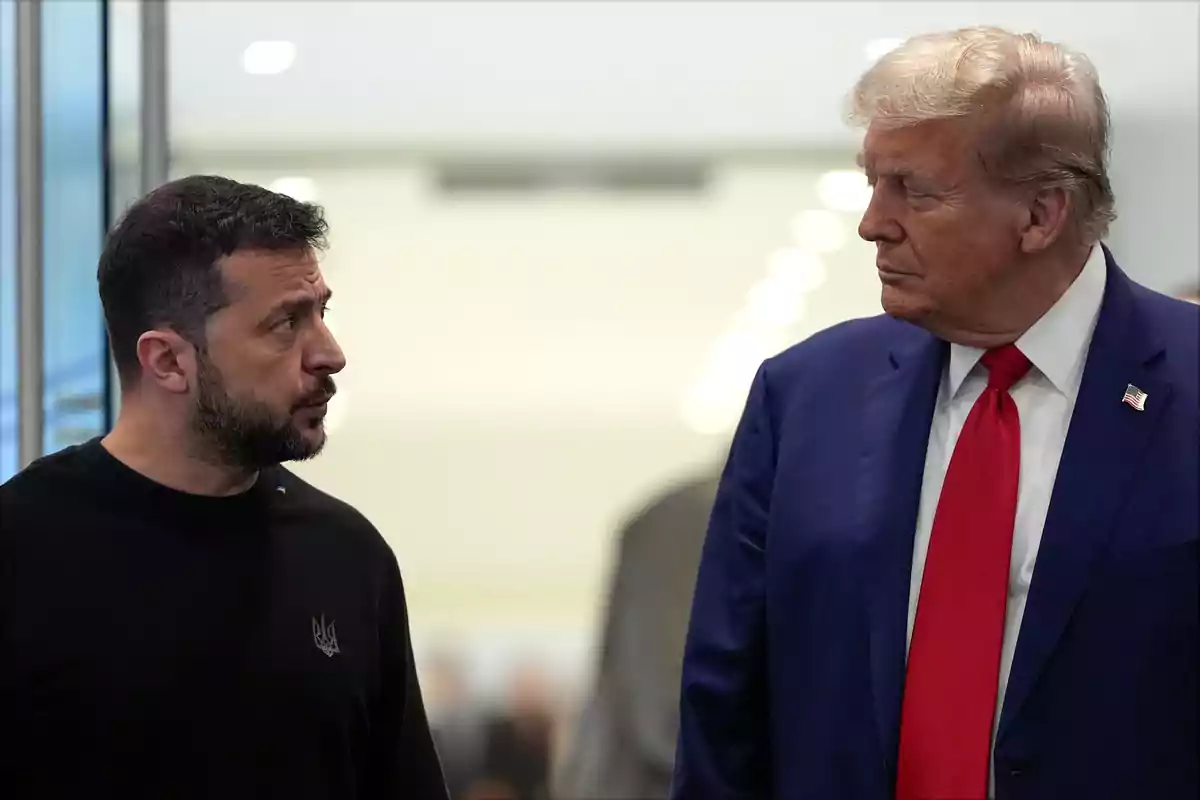 Dos hombres de pie mirándose y conversando en un entorno interior iluminado Dos hombres de pie mirándose y conversando en un entorno interior iluminado