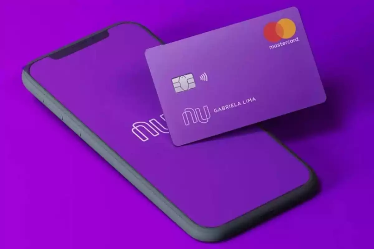 Teléfono móvil y tarjeta de crédito morada de Nubank sobre una superficie púrpura Teléfono móvil y tarjeta de crédito morada de Nubank sobre una superficie púrpura