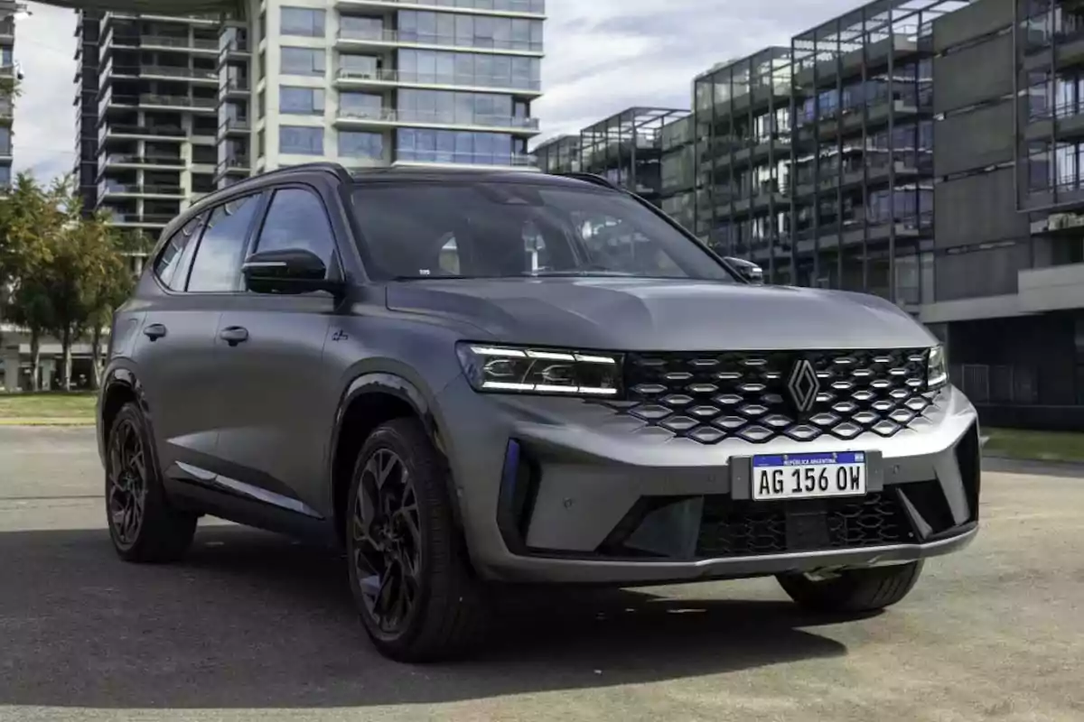 Gray Renault SUV parked in front of modern buildings in a city Gray Renault SUV parked in front of modern buildings in a city