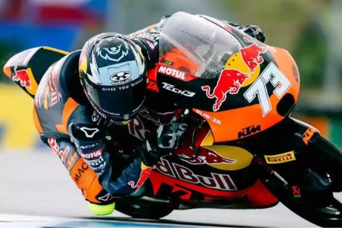 Piloto de motociclismo tomando una curva a gran velocidad con una moto KTM decorada con logotipos de Red Bull y el número 73 Piloto de motociclismo tomando una curva a gran velocidad con una moto KTM decorada con logotipos de Red Bull y el número 73
