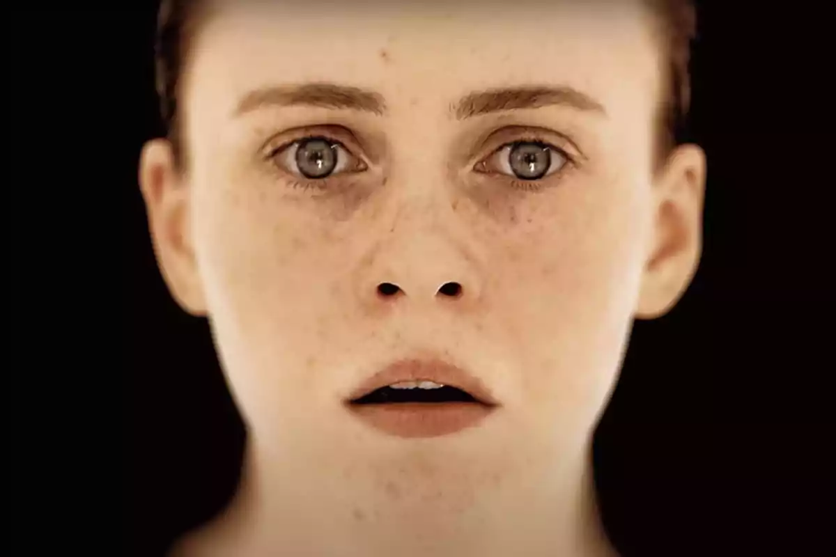 Face of a young person with a serious expression and a dark background Face of a young person with a serious expression and a dark background