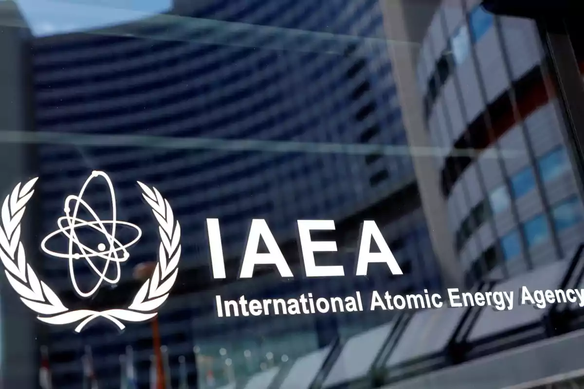 Logo of the International Atomic Energy Agency on a window with the reflection of a modern building Logo of the International Atomic Energy Agency on a window with the reflection of a modern building