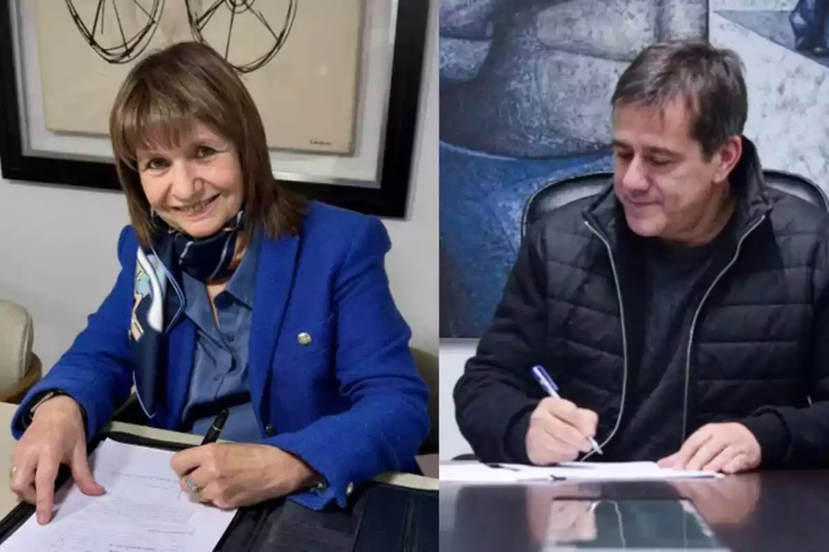 Dos personas sentadas en escritorios diferentes firmando documentos, una mujer con saco azul y un hombre con campera negra