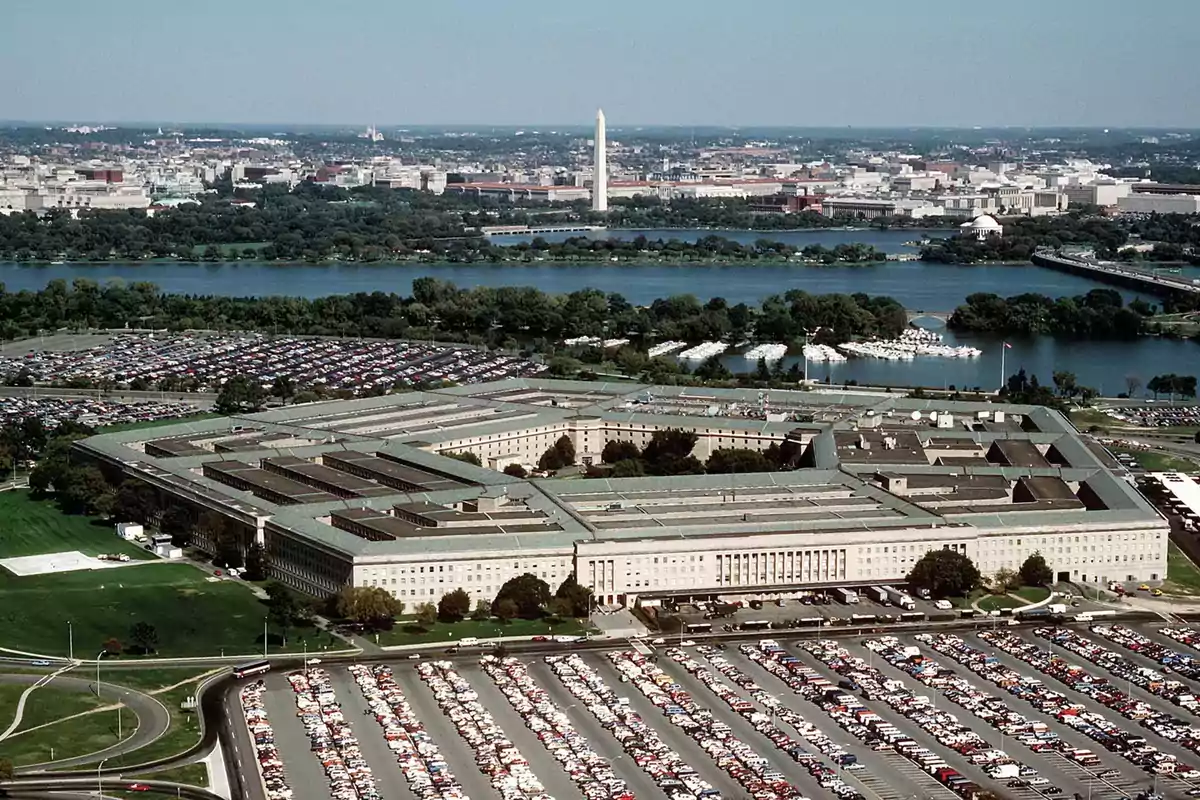 Aerial view of the Pentagon building with parking lots full of cars and the city of Washington, D.C. in the background Aerial view of the Pentagon building with parking lots full of cars and the city of Washington, D.C. in the background