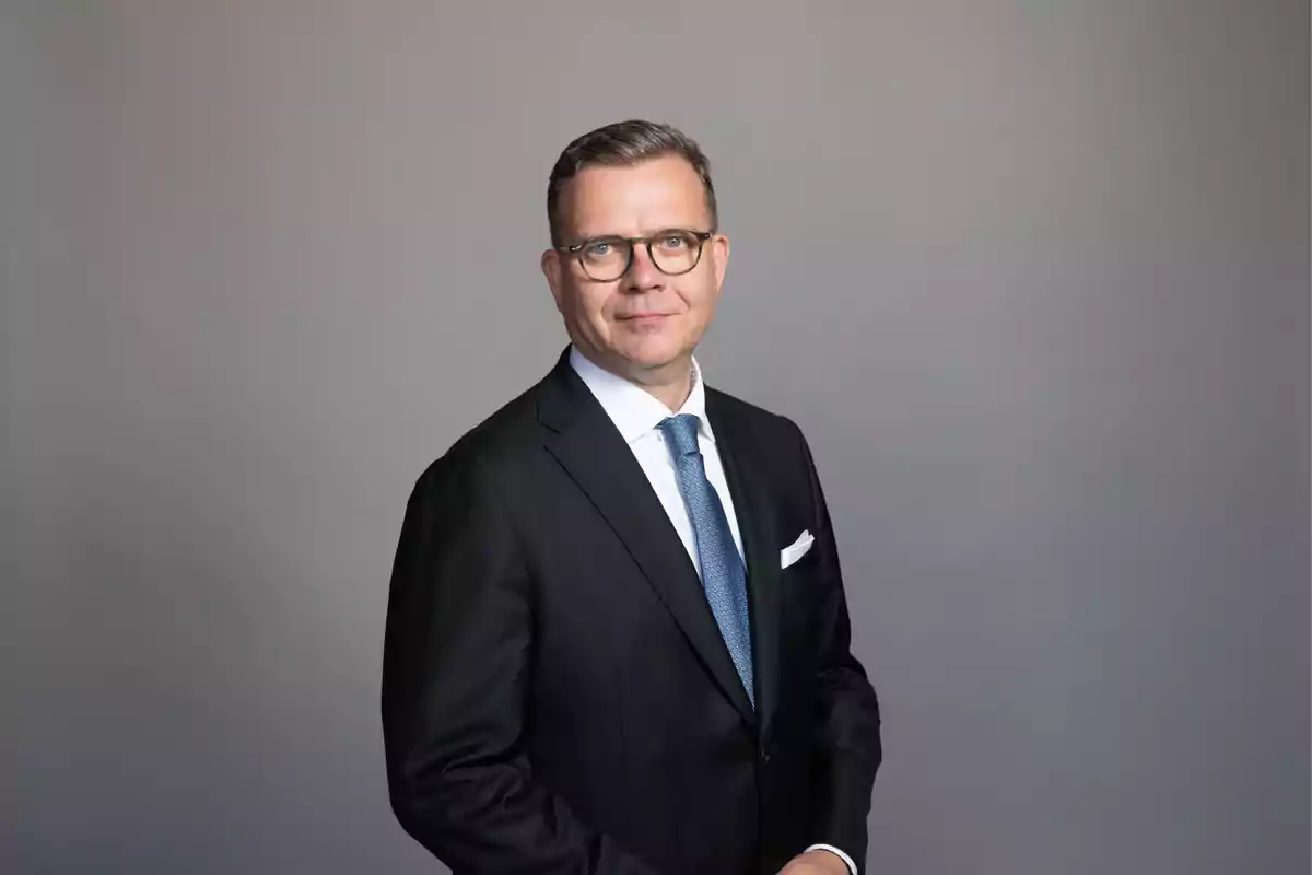 Middle-aged man with glasses and a dark suit posing in front of a gray background Middle-aged man with glasses and a dark suit posing in front of a gray background
