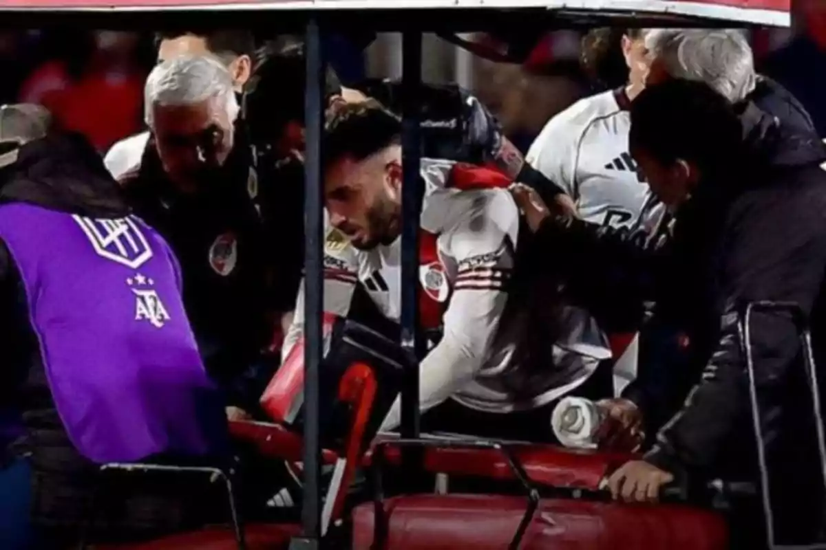 Un futbolista de River Plate es asistido por el cuerpo médico y subido a una camilla durante un partido