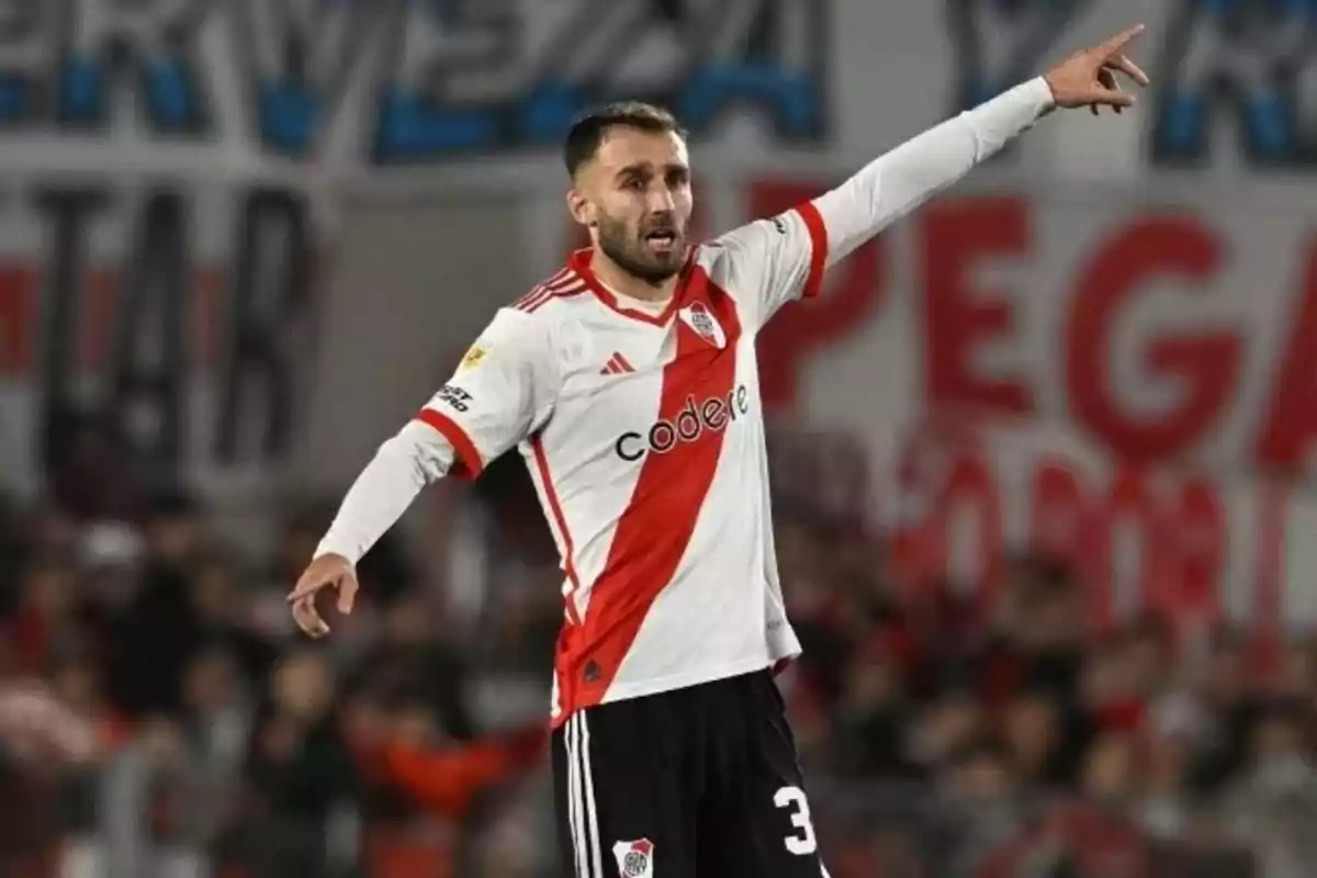 Futbolista de River Plate con uniforme blanco y banda roja señalando con el brazo derecho durante un partido Futbolista de River Plate con uniforme blanco y banda roja señalando con el brazo derecho durante un partido