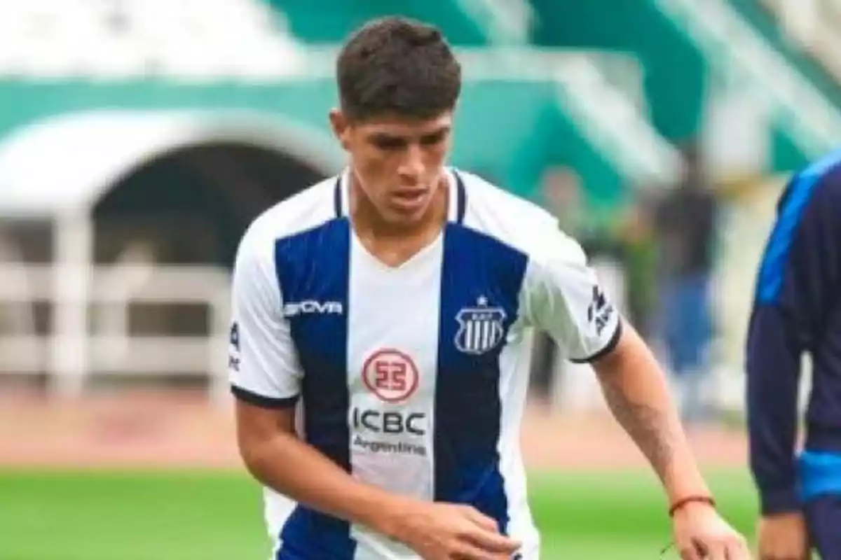 Jugador de fútbol con uniforme de Talleres de Córdoba en el campo de juego Jugador de fútbol con uniforme de Talleres de Córdoba en el campo de juego
