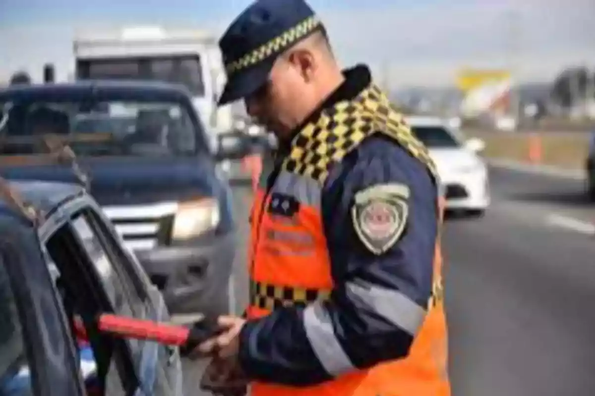 Oficial de tránsito revisando un automóvil en un retén vial durante el día Oficial de tránsito revisando un automóvil en un retén vial durante el día